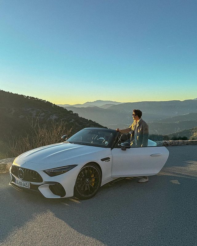 George Russell posing with his Mercedes-AMG SL63