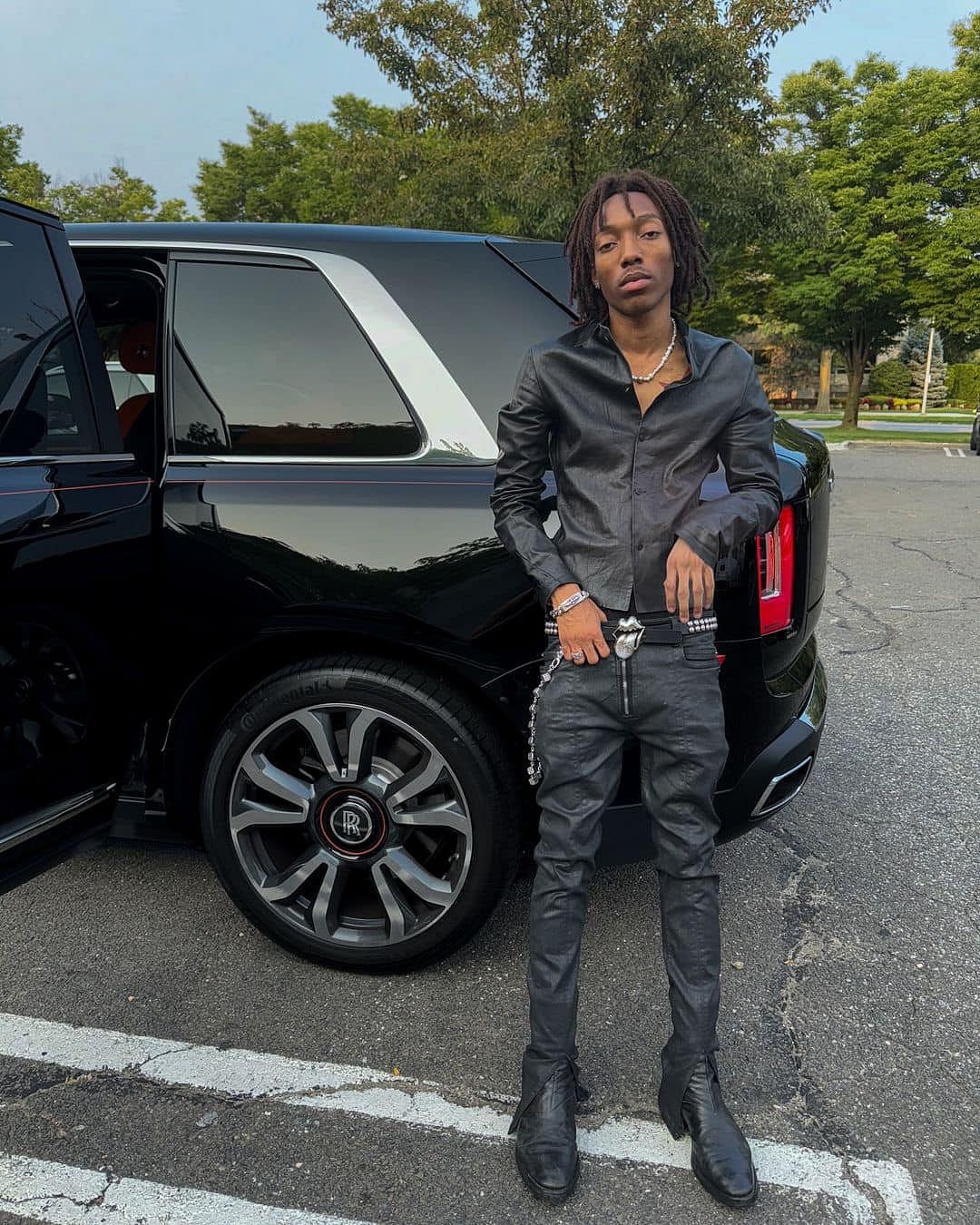 Lil Tecca posing with his Rolls-Royce Cullinan