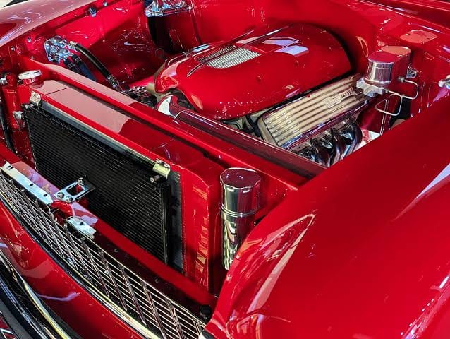Restored vintage inline six-cylinder engine bay with chrome carburetors